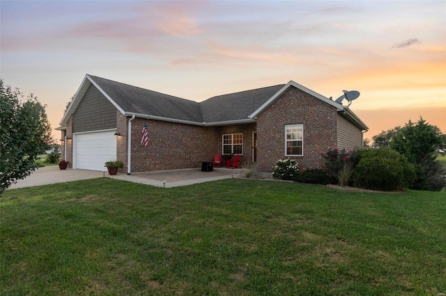 ranch-style house featuring a garage, concrete driveway, brick siding, and a front yard