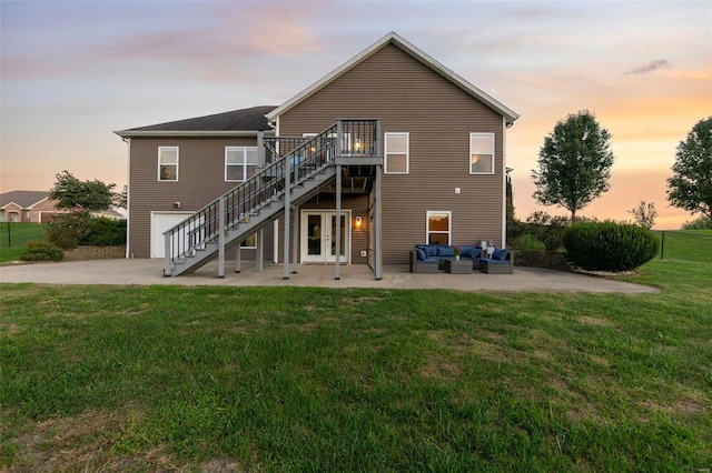 back house at dusk featuring an outdoor hangout area, a deck, a lawn, and a patio