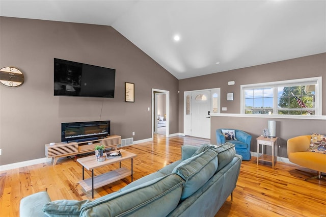 living room featuring wood-type flooring and vaulted ceiling