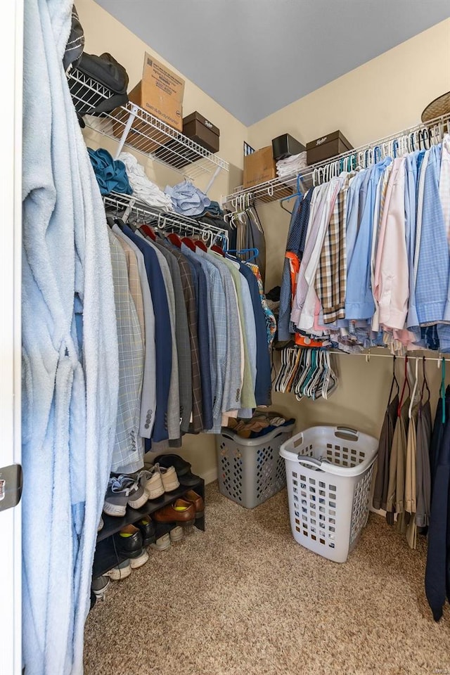 walk in closet featuring light colored carpet