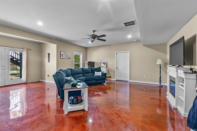 living room with ceiling fan and concrete flooring