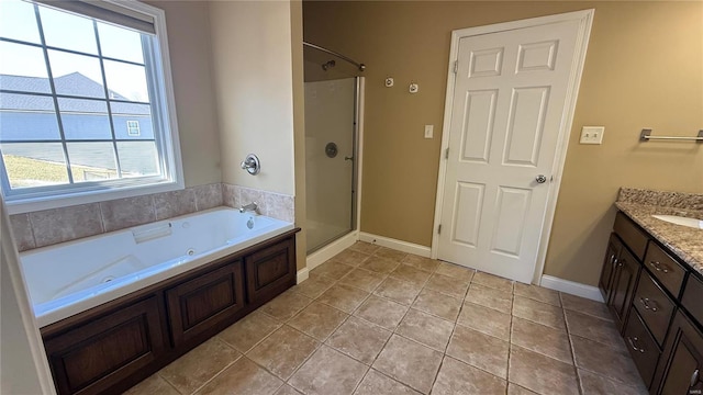 full bath with a shower stall, vanity, a jetted tub, baseboards, and tile patterned floors