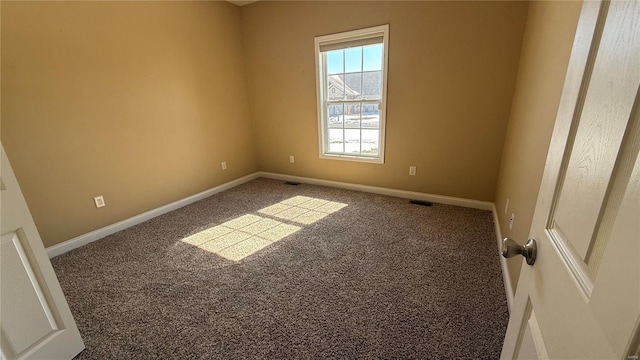 empty room featuring carpet flooring, visible vents, and baseboards