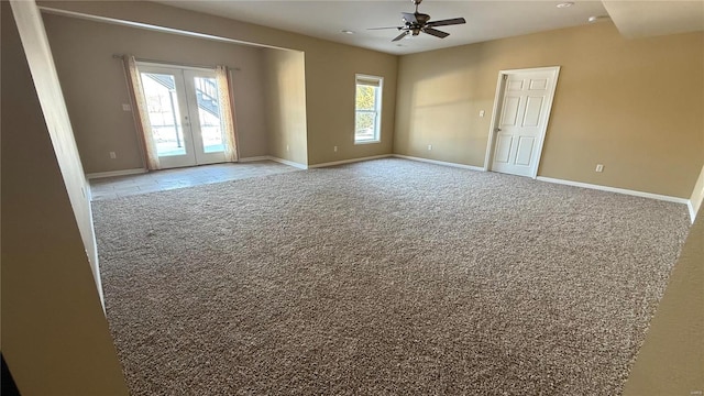 empty room with baseboards, light colored carpet, a ceiling fan, and french doors