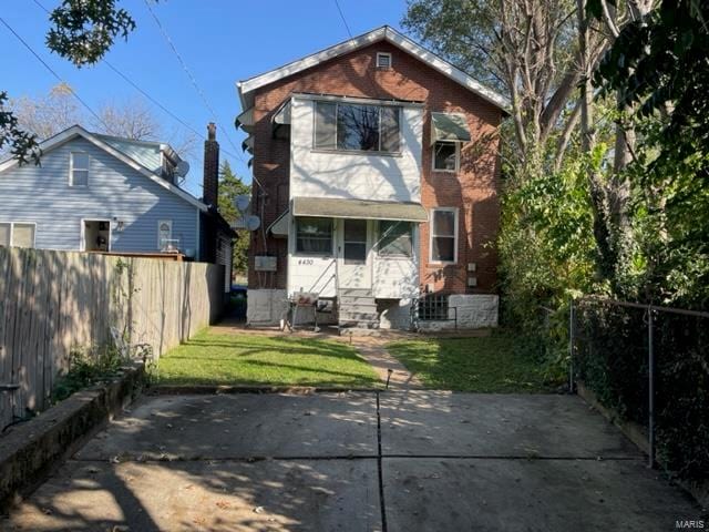 rear view of property featuring a yard