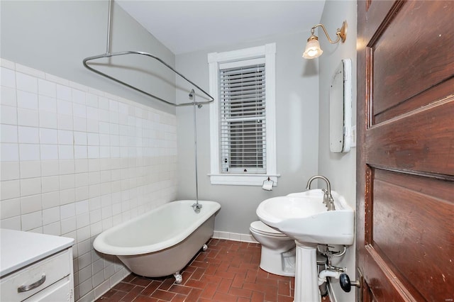 bathroom with toilet, a tub to relax in, and tile walls