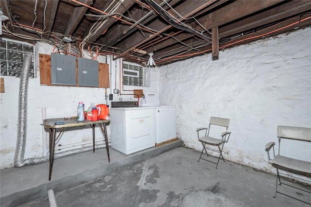 basement featuring electric panel and washing machine and clothes dryer