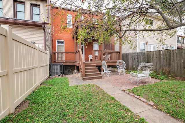 view of yard with central AC unit, a patio area, and a wooden deck