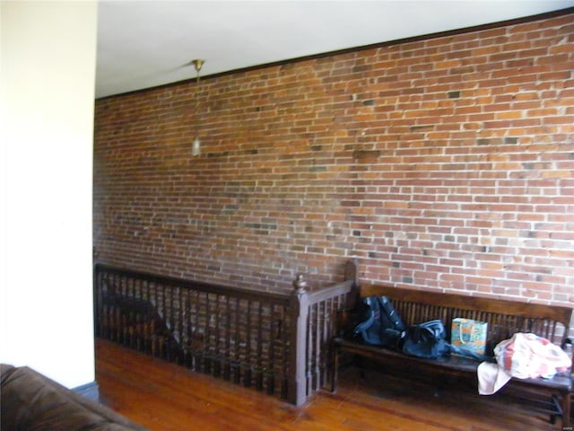 interior space featuring hardwood / wood-style flooring and brick wall