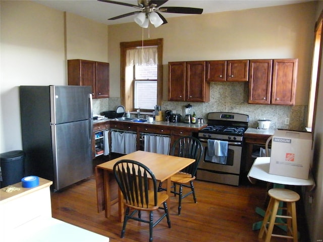 kitchen featuring ceiling fan, sink, dark hardwood / wood-style flooring, backsplash, and appliances with stainless steel finishes