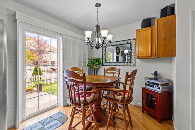 dining area with a chandelier and light hardwood / wood-style flooring