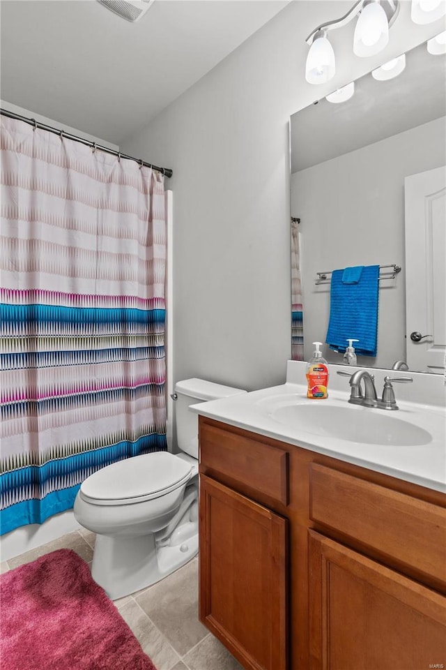 bathroom featuring tile patterned flooring, vanity, and toilet