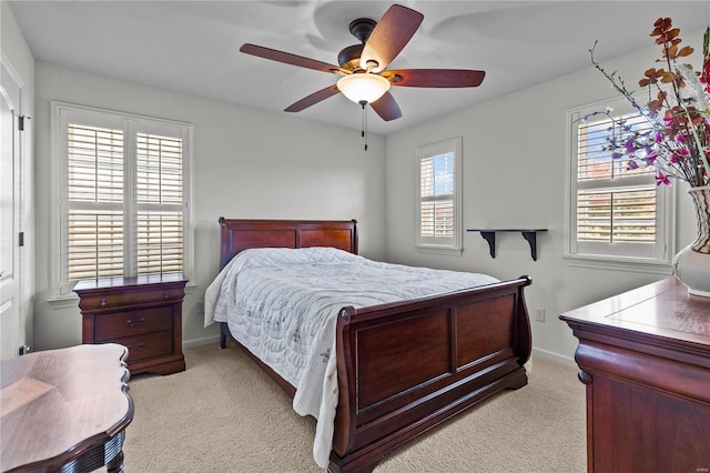 carpeted bedroom with multiple windows and ceiling fan