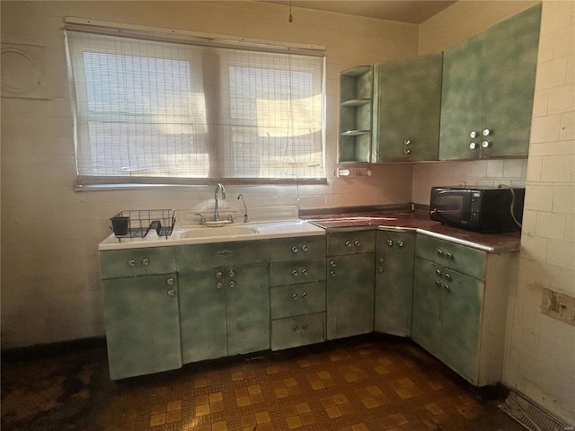 kitchen featuring green cabinets and sink