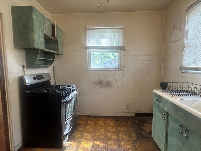 kitchen featuring stainless steel gas range oven and green cabinetry