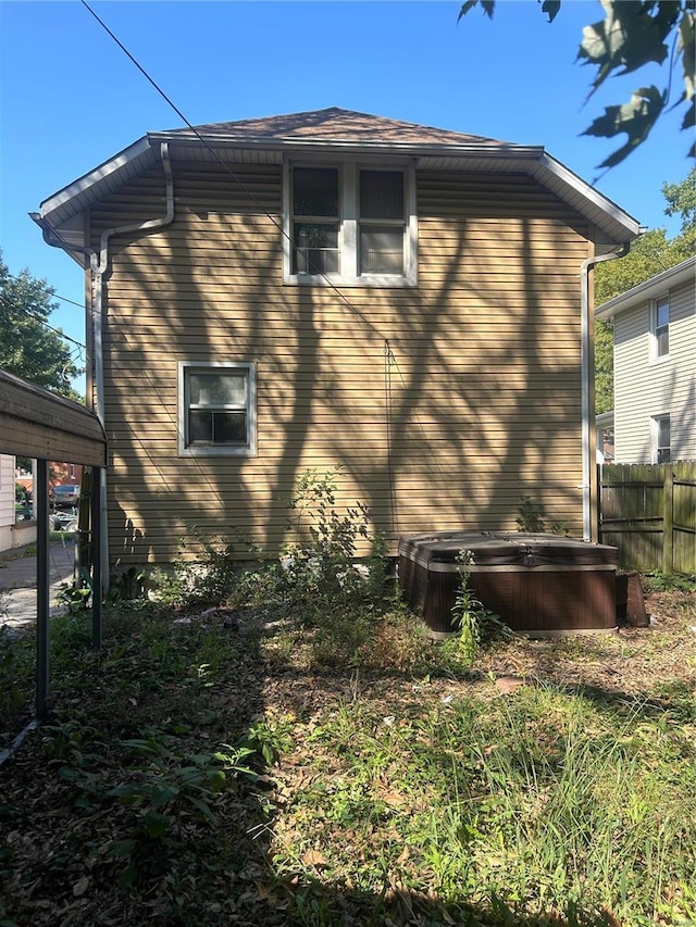 view of home's exterior featuring a covered hot tub