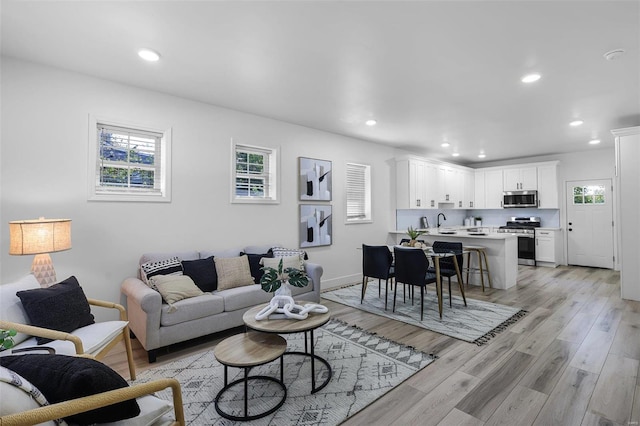 living room featuring sink and light hardwood / wood-style floors