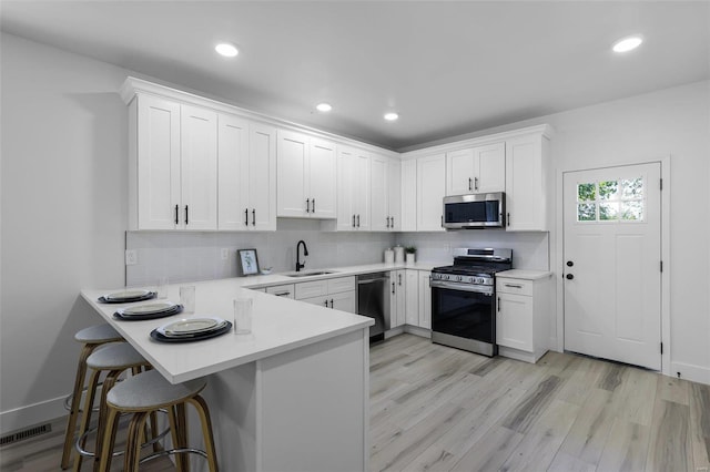 kitchen featuring stainless steel appliances, sink, and white cabinetry