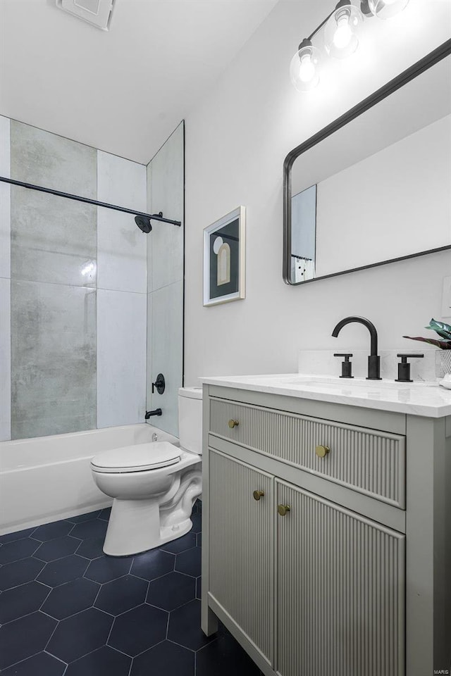 full bathroom with tiled shower / bath, tile patterned floors, vanity, and toilet