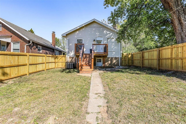 back of property with central AC, a yard, and a wooden deck