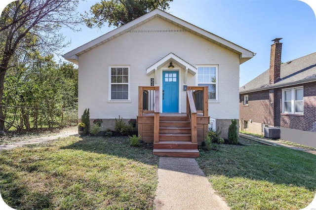 view of front of house with a front yard and central air condition unit