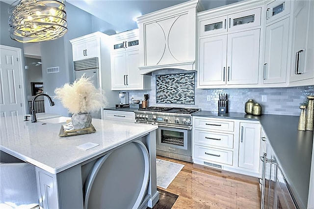 kitchen with premium appliances, glass insert cabinets, and white cabinets