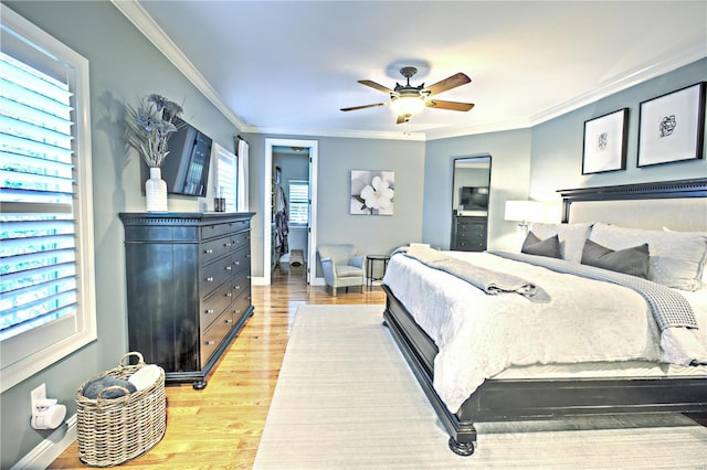 bedroom with ornamental molding, baseboards, ceiling fan, and light wood finished floors