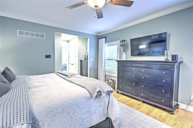 bedroom with crown molding, visible vents, a ceiling fan, wood finished floors, and baseboards