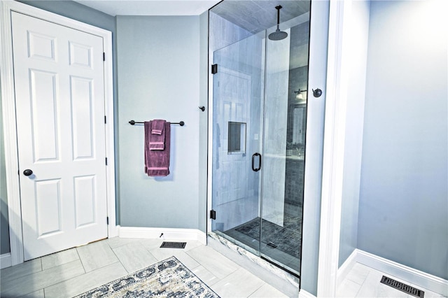 full bathroom with a shower stall and baseboards