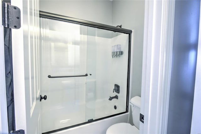 bathroom with shower / bath combination with glass door and toilet