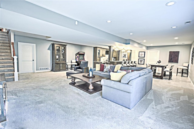 living room featuring light carpet, visible vents, stairway, and recessed lighting