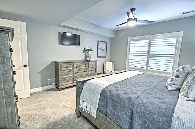 bedroom featuring a ceiling fan, light colored carpet, visible vents, and baseboards