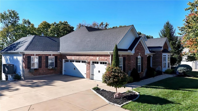 view of front facade with a garage, driveway, a front lawn, central AC, and brick siding