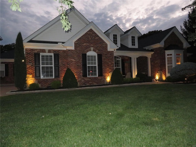 view of front of home with a yard and brick siding