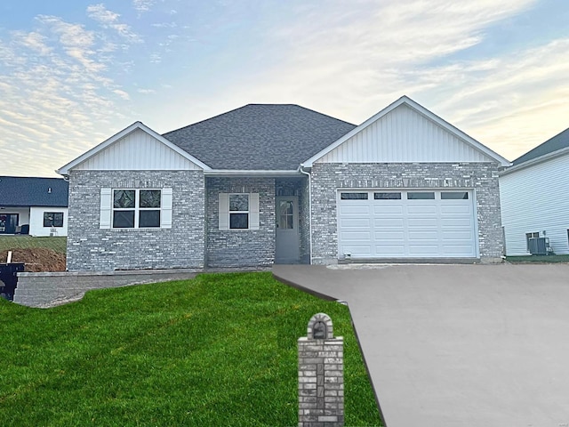 view of front of house featuring central AC, a garage, and a yard