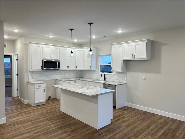 kitchen featuring a center island, stainless steel appliances, white cabinetry, and sink