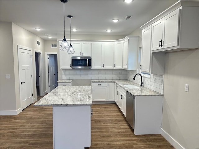 kitchen featuring sink, a kitchen island, dark hardwood / wood-style flooring, white cabinetry, and stainless steel appliances