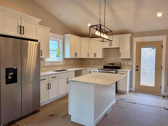 kitchen featuring stainless steel appliances, white cabinetry, a kitchen island, and vaulted ceiling