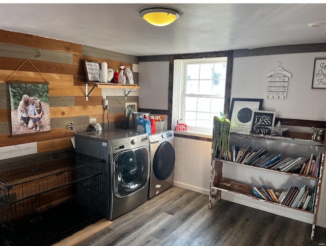 laundry room featuring hardwood / wood-style floors, washer and clothes dryer, and wood walls