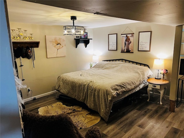 bedroom featuring dark hardwood / wood-style flooring and a notable chandelier