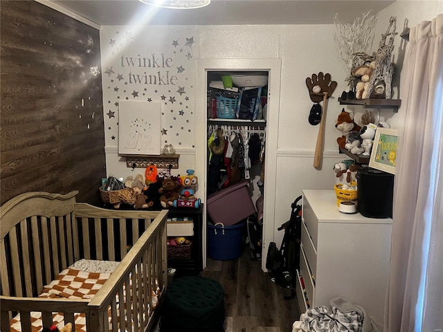 bedroom with dark hardwood / wood-style flooring, a crib, and a closet