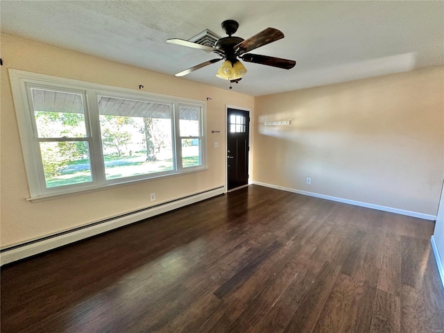 spare room featuring ceiling fan, dark hardwood / wood-style flooring, and baseboard heating