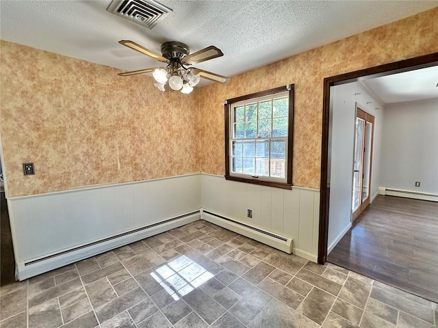 unfurnished room with baseboard heating, ceiling fan, and a textured ceiling