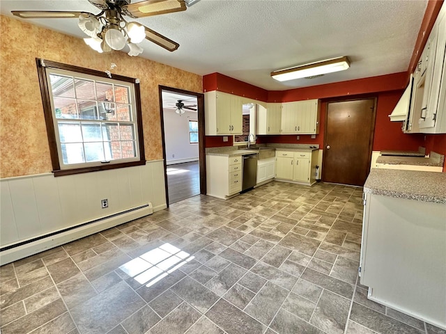 kitchen with cream cabinets, a textured ceiling, a baseboard radiator, and stainless steel dishwasher