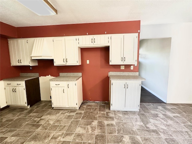 kitchen featuring white cabinets and a textured ceiling