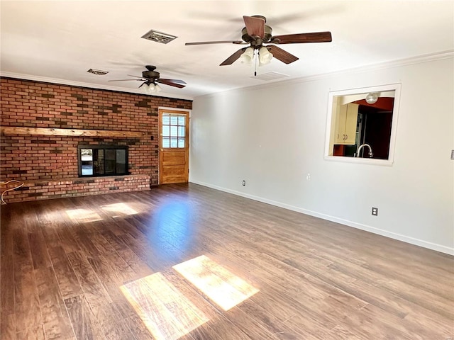 unfurnished living room featuring crown molding, hardwood / wood-style floors, ceiling fan, and a brick fireplace