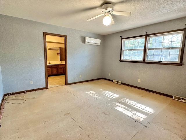 unfurnished bedroom with ceiling fan, ensuite bathroom, and a wall unit AC