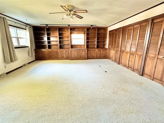 unfurnished living room featuring a textured ceiling, built in features, and carpet floors