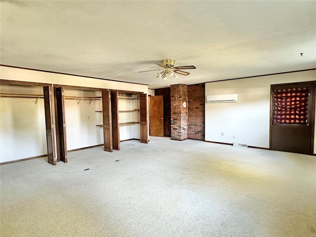 empty room featuring a wall mounted AC, ceiling fan, carpet, and a textured ceiling