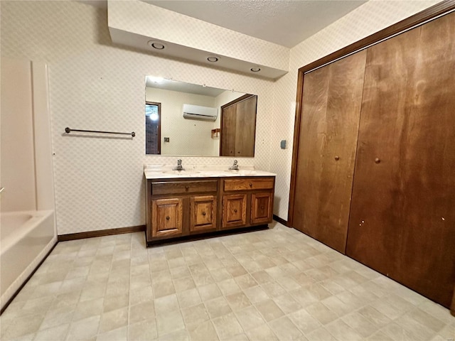 bathroom with a textured ceiling, vanity, and a wall unit AC